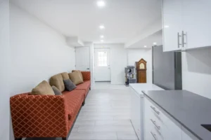 Basement remodeling and renovation with cozy seating area and bright lighting by Designs by D and J.