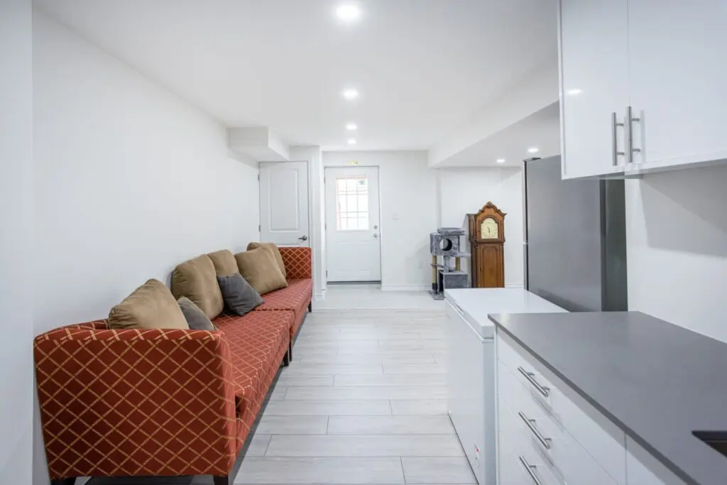 Basement remodeling and renovation with cozy seating area and bright lighting by Designs by D and J.